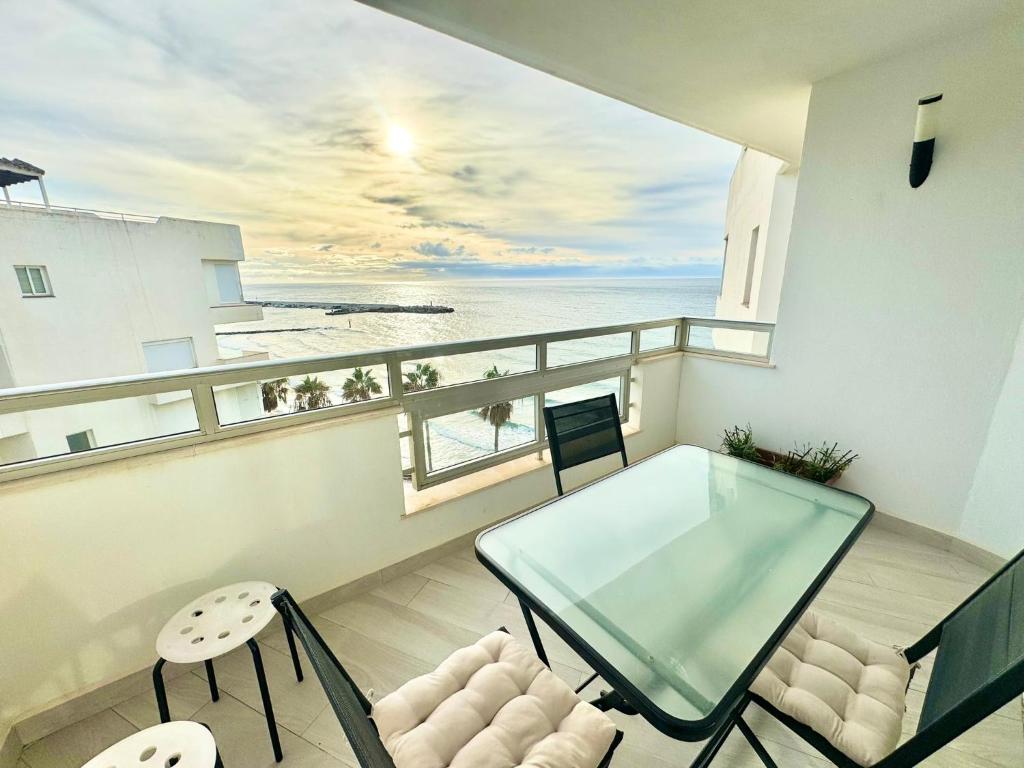 a balcony with a glass table and chairs and the ocean at SEA VIEW & BEACH ACCESS - Center - Parking in Marbella