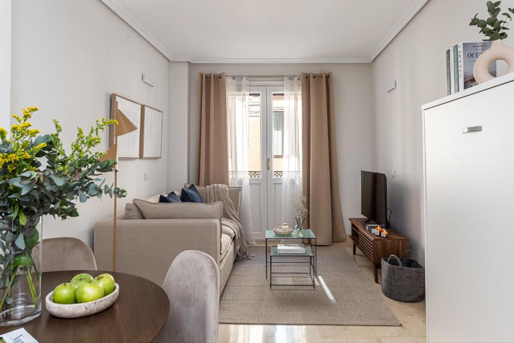uma sala de estar com um sofá e uma mesa em BNBHolder Loving Gran Via Apartment III em Madri