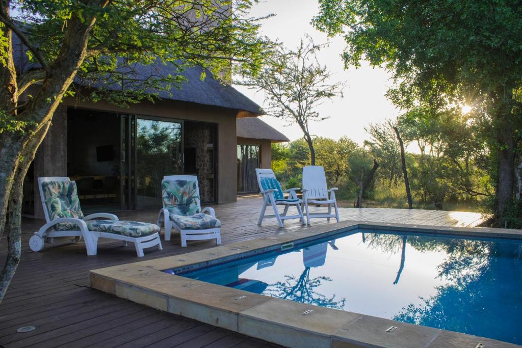 une terrasse avec des chaises et une piscine dans l'établissement Duiker lodge, à Mmukubyane