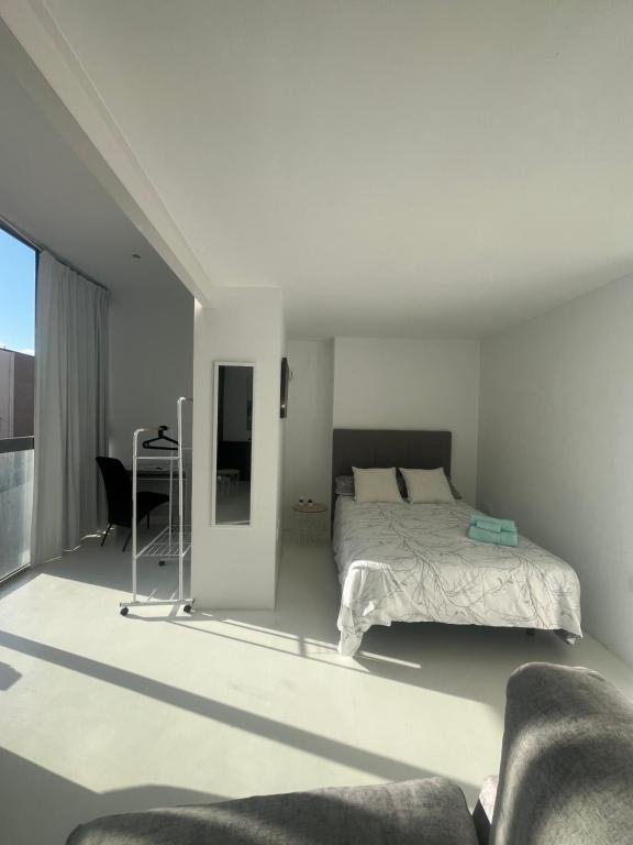 Habitación blanca con cama y escritorio en Estudio triple con terraza y vistas en el centro en Albacete