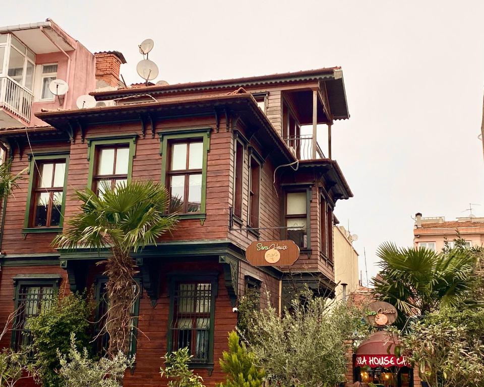 uma antiga casa de madeira com uma palmeira em frente em Ottoman Suites by Sera House em Istambul