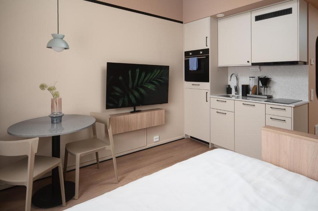 a small kitchen with a table and a bed in a room at Sky Hotel Apartments, Stockholm in Stockholm