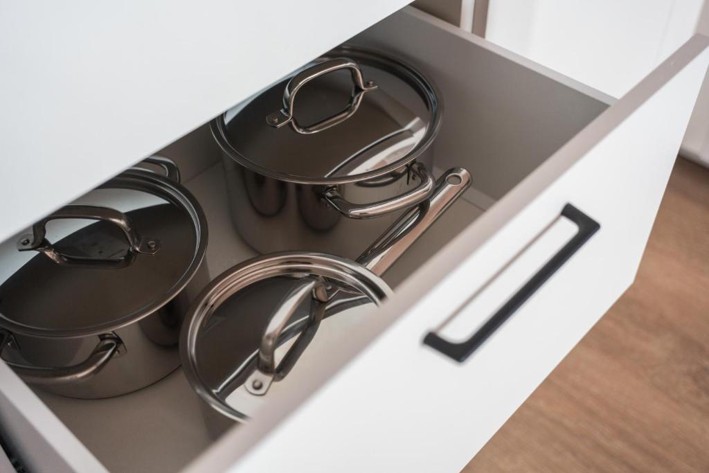 two pots and pans in a drawer of a kitchen at Sky Hotel Apartments, Stockholm in Stockholm