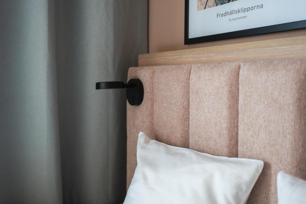 a bed with a pillow and a tv on a wall at Sky Hotel Apartments, Stockholm in Stockholm