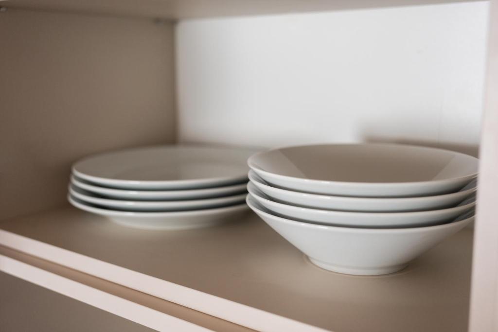 two stacks of plates and bowls sitting on a shelf at Sky Hotel Apartments, Stockholm in Stockholm