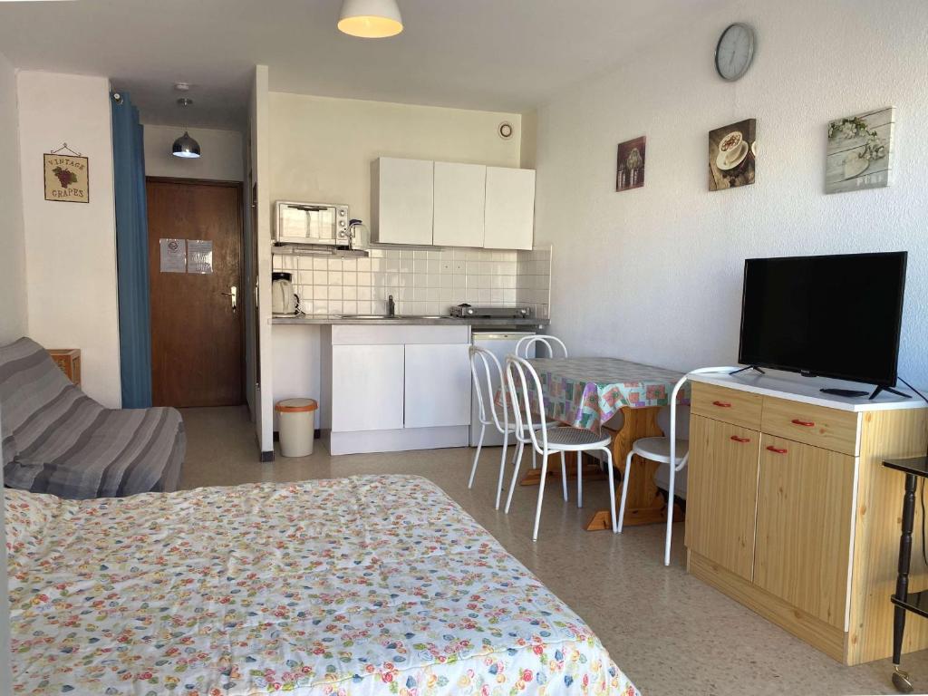 une chambre avec un lit et une cuisine avec une télévision dans l'établissement Studio Balaruc-les-Bains, 1 pièce, 2 personnes - FR-1-553-99, à Balaruc-les-Bains