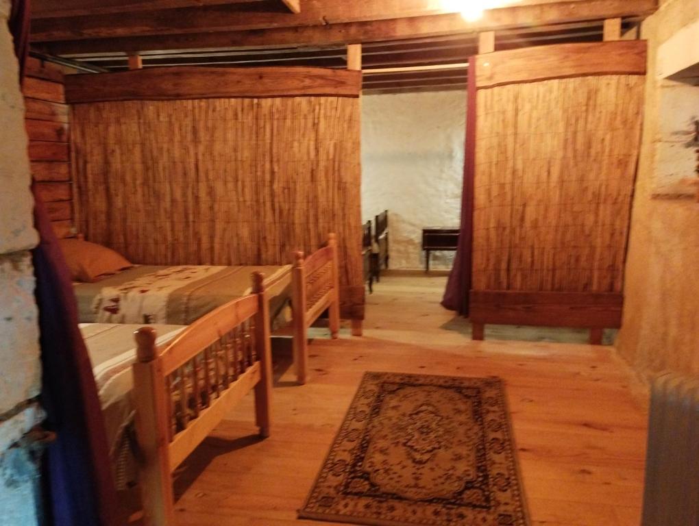 Habitación con 2 camas y alfombra. en Cheval nomad' en La Goulaudie