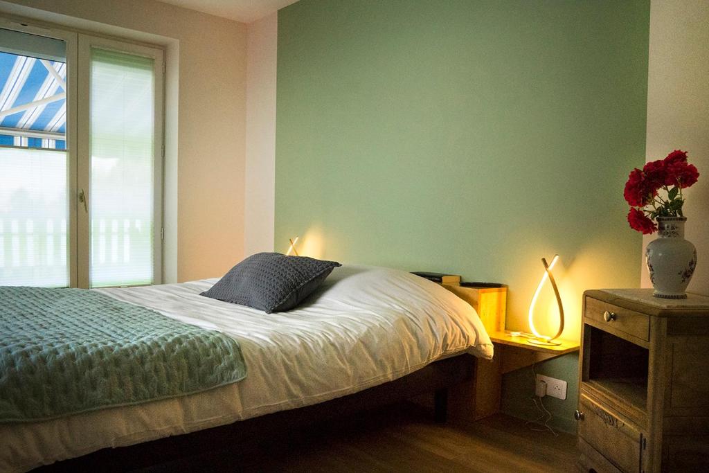 een slaapkamer met een bed met een raam en 2 lampen bij A l'appartement chez REVIGORA in Vienne