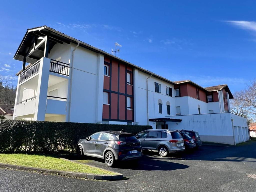 two cars parked in a parking lot in front of a building at Appartement Cambo-les-Bains, 2 pièces, 2 personnes - FR-1-495-30 in Cambo-les-Bains