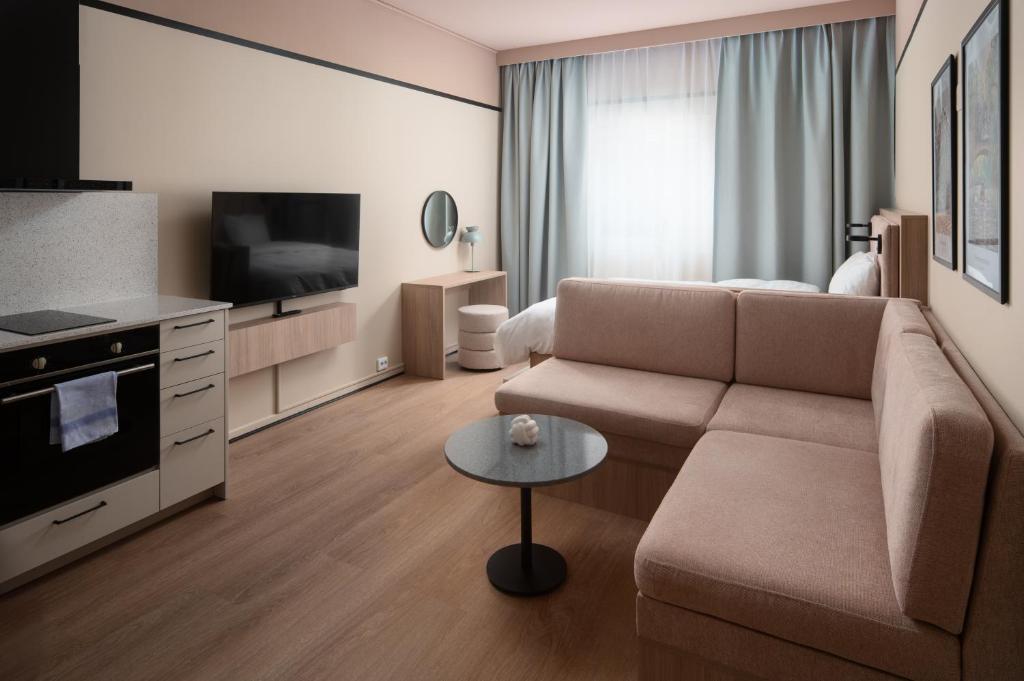 a living room with a couch and a television at Sky Hotel Apartments, Stockholm in Stockholm