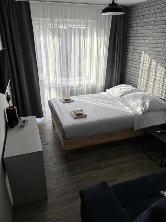 sypialnia z łóżkiem i dużym oknem w obiekcie Guest Apartments Orłowo w mieście Gdynia