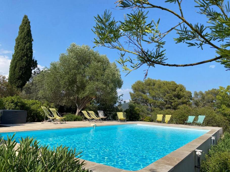 een zwembad in een tuin met stoelen en bomen bij Mas provençal dans un vignoble in La Motte