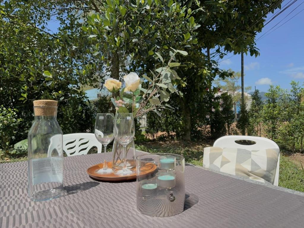 una mesa con copas de vino y un jarrón con flores en Prime Hill, en Ban Ket Ho