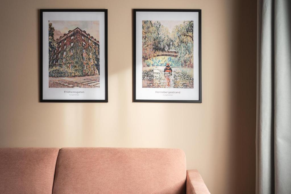 three framed pictures on a wall with a couch at Sky Hotel Apartments, Stockholm in Stockholm