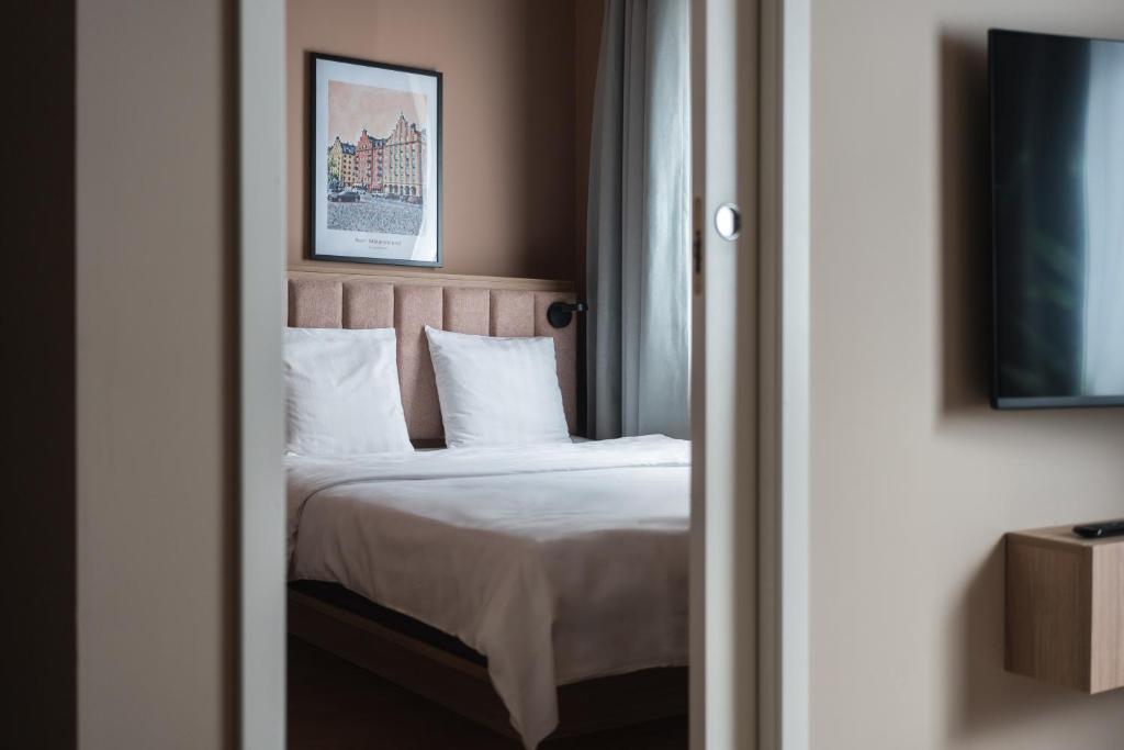a bedroom with a bed with white sheets and pillows at Sky Hotel Apartments, Stockholm in Stockholm
