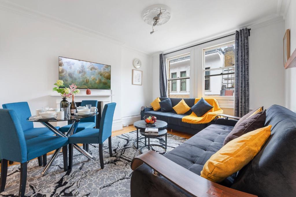 ein Wohnzimmer mit einem Sofa und einem Tisch in der Unterkunft Modern Living in the Heart of Covent Garden! 6BC in London