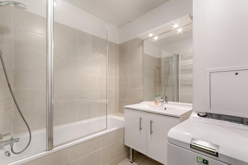 a white bathroom with a shower and a sink at Resident- Beautiful 6P apartment in Montrouge