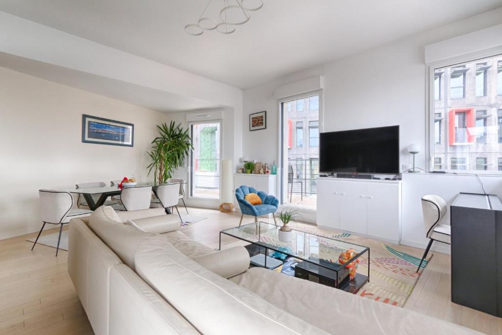 a living room with a white couch and a tv at Resident- Beautiful 6P apartment in Montrouge