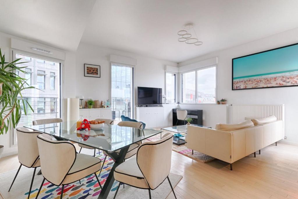 a living room with a glass table and chairs at Resident- Beautiful 6P apartment in Montrouge