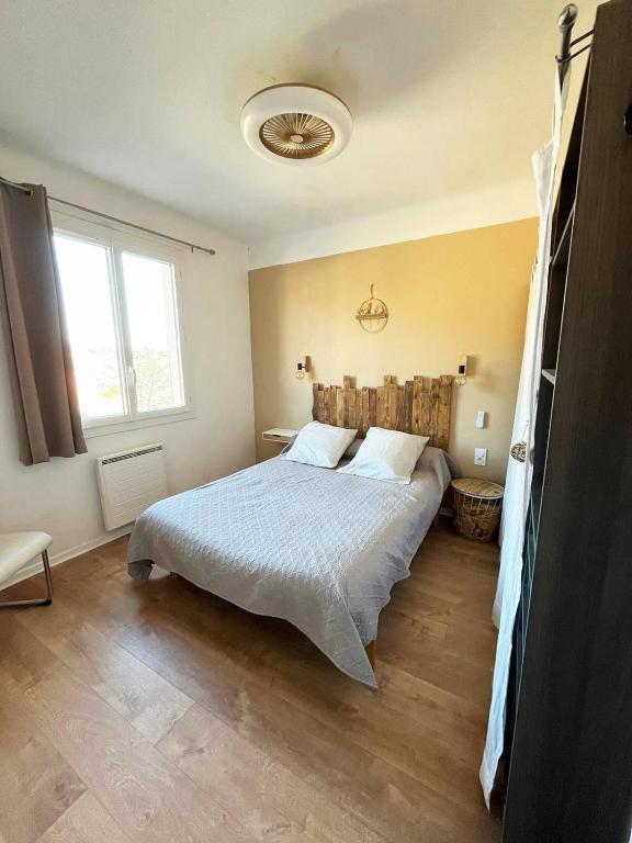 a bedroom with a bed and a large window at Merveilleux appartement style nature proche centre ville in Collioure