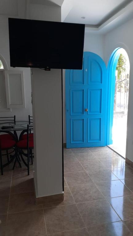 Zimmer mit blauer Tür und TV auf einer Säule in der Unterkunft monolocale a Sharm el Sheikh in Sharm El Sheikh