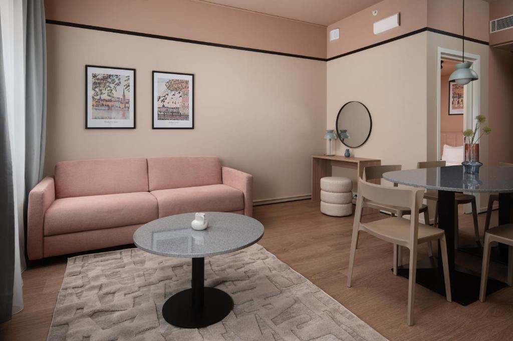 a living room with a couch and a table at Sky Hotel Apartments, Stockholm in Stockholm