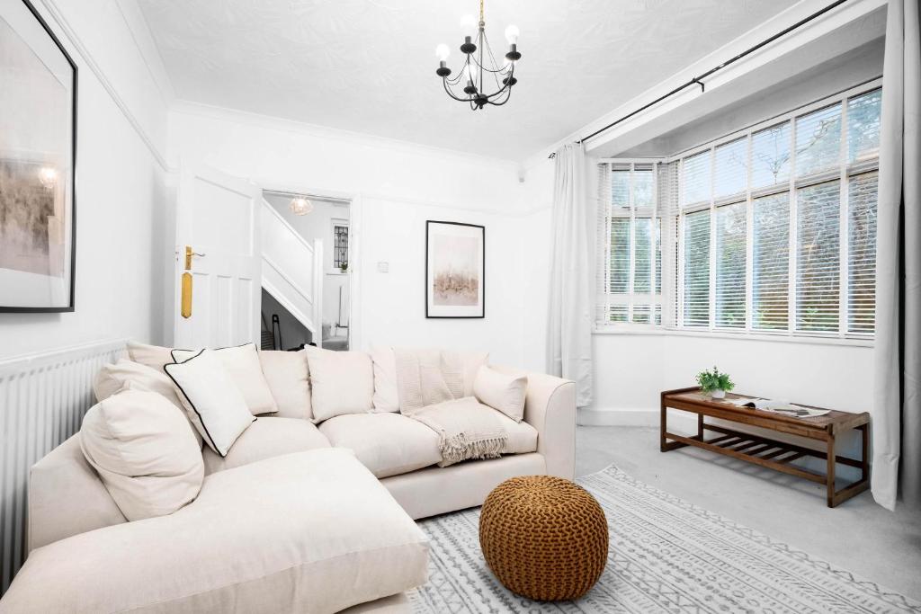 Sala de estar blanca con sofá y mesa en Large Luxury 4 Bedroom House - Off-street Parking - Garden - Wifi - Netflix - 11M, en Northfield