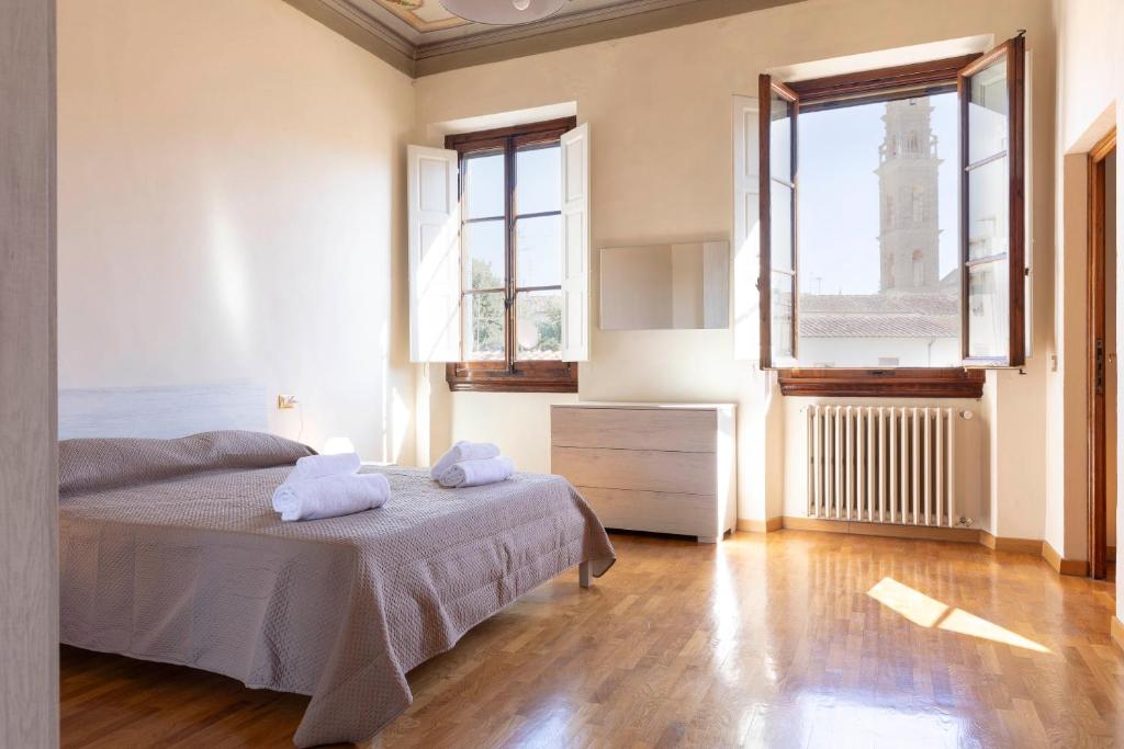 ein Schlafzimmer mit einem Bett und einem großen Fenster in der Unterkunft Santo Spirito Exclusive Apartment in Florenz