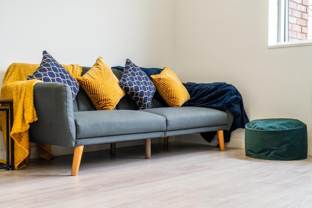 un sofá con almohadas en la sala de estar en Luxury 1 Bedroom serviced apartment with Roof terrace & Gym, en Stevenage