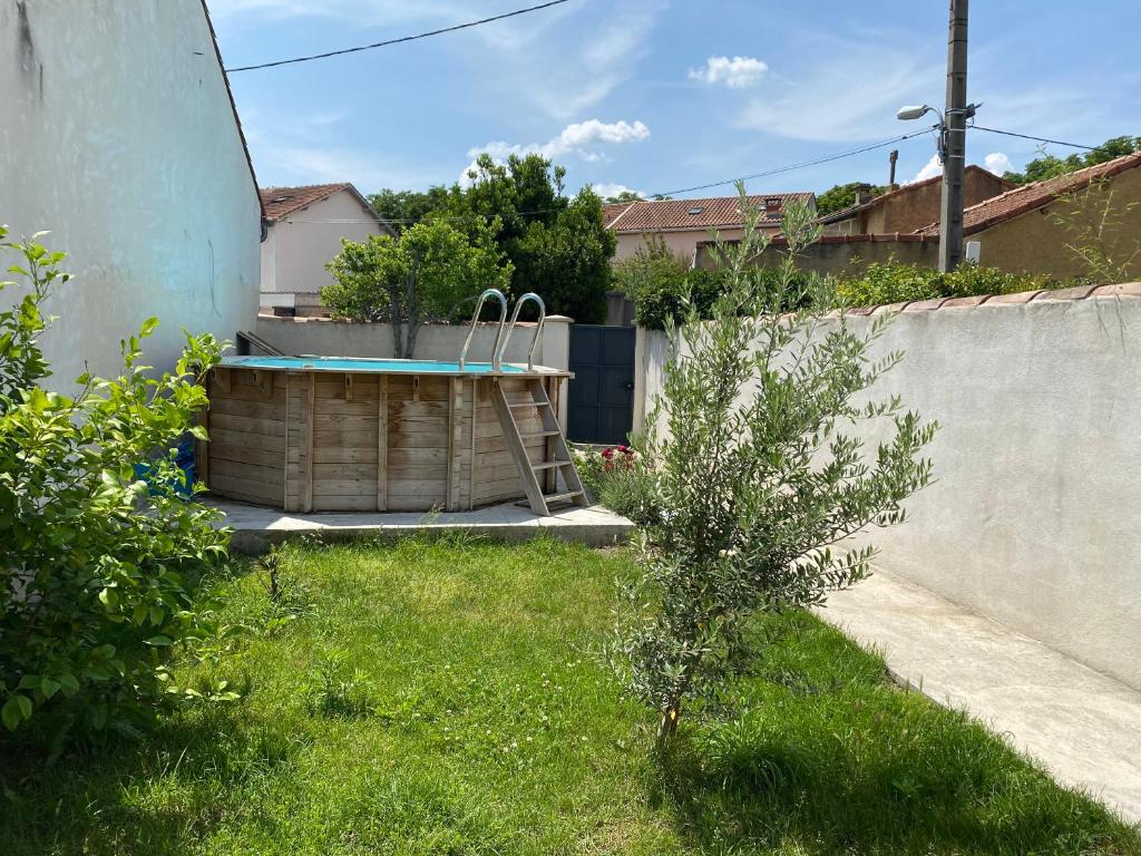 uma pequena árvore num quintal ao lado de uma cerca em Maison trois chambres, près remparts, jardin, piscine em Avignon