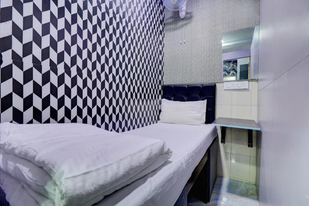 Ce petit lit se trouve dans un dortoir décoré en noir et blanc. dans l'établissement Ared Space-Near Vile Parle Railway Station, à Mumbai