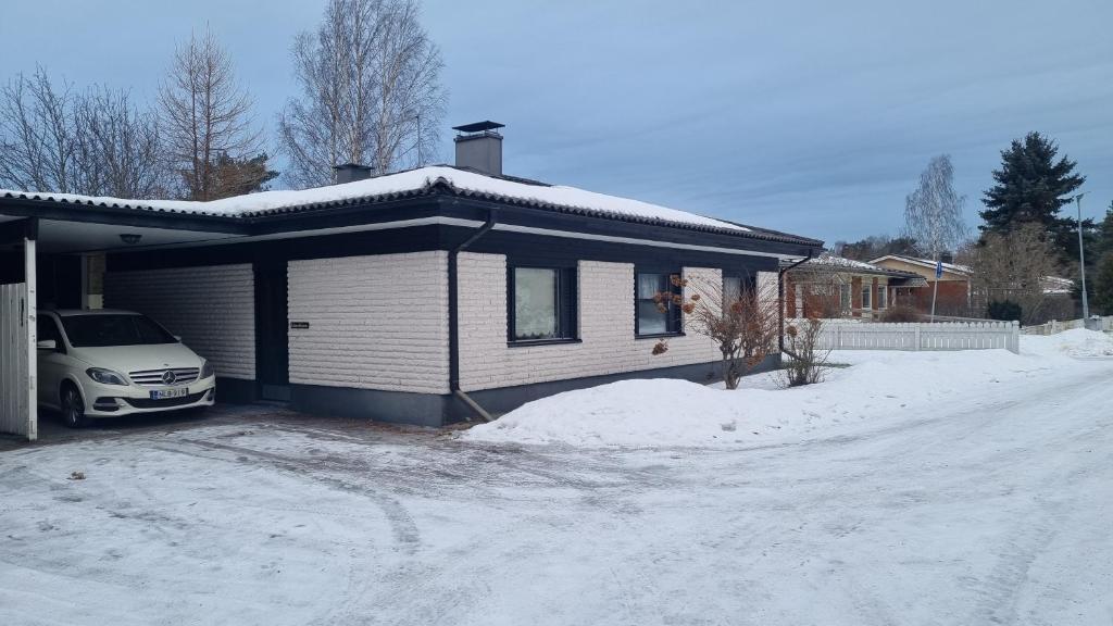 une maison avec une voiture garée dans la neige dans l'établissement 3 bedrooms, sauna and kitchen All house, à Pori