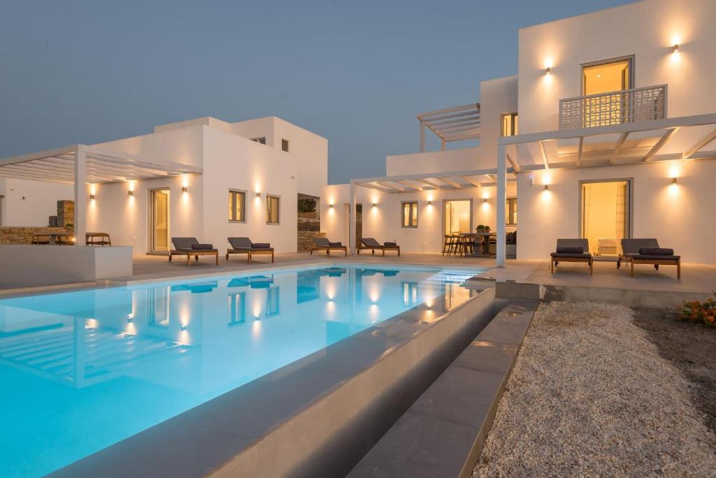 a house with a swimming pool in front of it at Beautiful Paros Villa - 1 Bedroom - The Calming Villa - Wonderful Sea Views and Jacuzzi - Naousa in Livadia