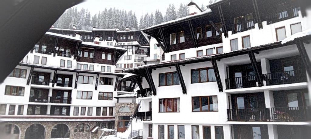 a group of apartment buildings with snow on them at Arendo Snow апартамент в Grand Monastery in Pamporovo