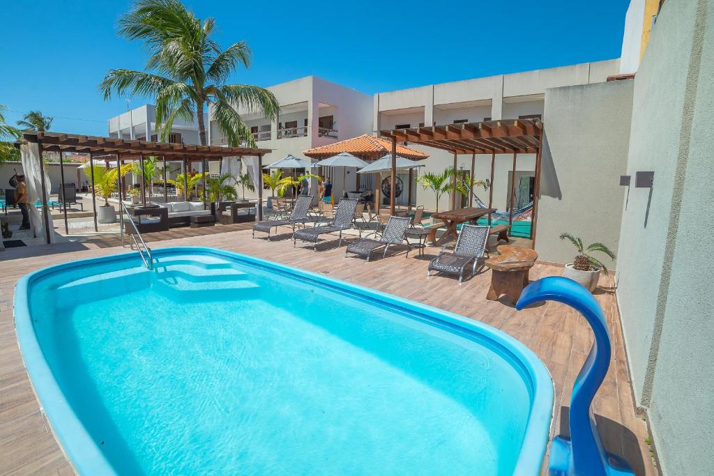 a swimming pool next to a building with a resort at Pousada Maré do Francês in Praia do Frances