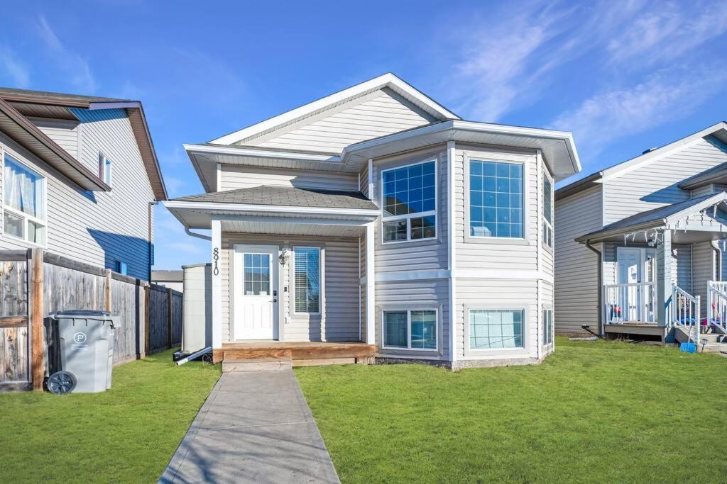 a large white house with a grass yard at Cozy Countryside Crib in Grande Prairie