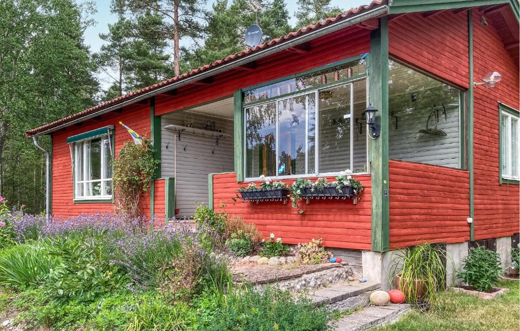 uma casa vermelha com flores à frente em 3 Bedroom Lovely Home In Vrena em Vrena