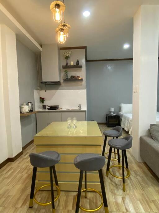 a kitchen with three bar stools in a room at Balai ni Atan - relaxing studio unit near airport in General Santos
