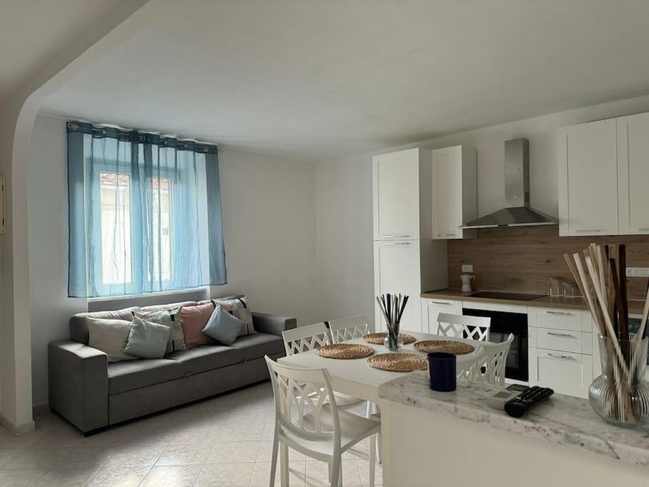 cocina y sala de estar con sofá y mesa en La Casa Di Nonno Roberto, en Livorno