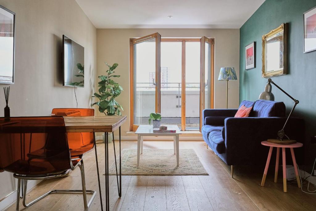 a living room with a couch and a table at Sunny Shoreditch Oasis Canal Views & Urban Charm in London