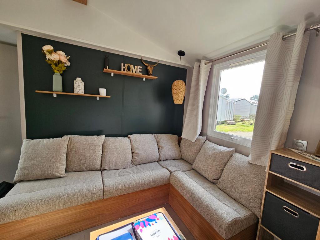 - un salon avec un canapé et une fenêtre dans l'établissement Jolie Mobil home 2 chambres (198), à Saint-Jean-de-Monts