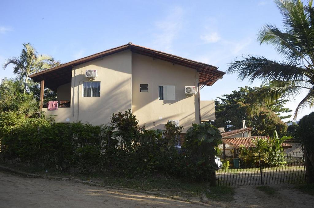 una casa blanca con una valla delante en Suítes Paquetá Ilhabela, en Ilhabela