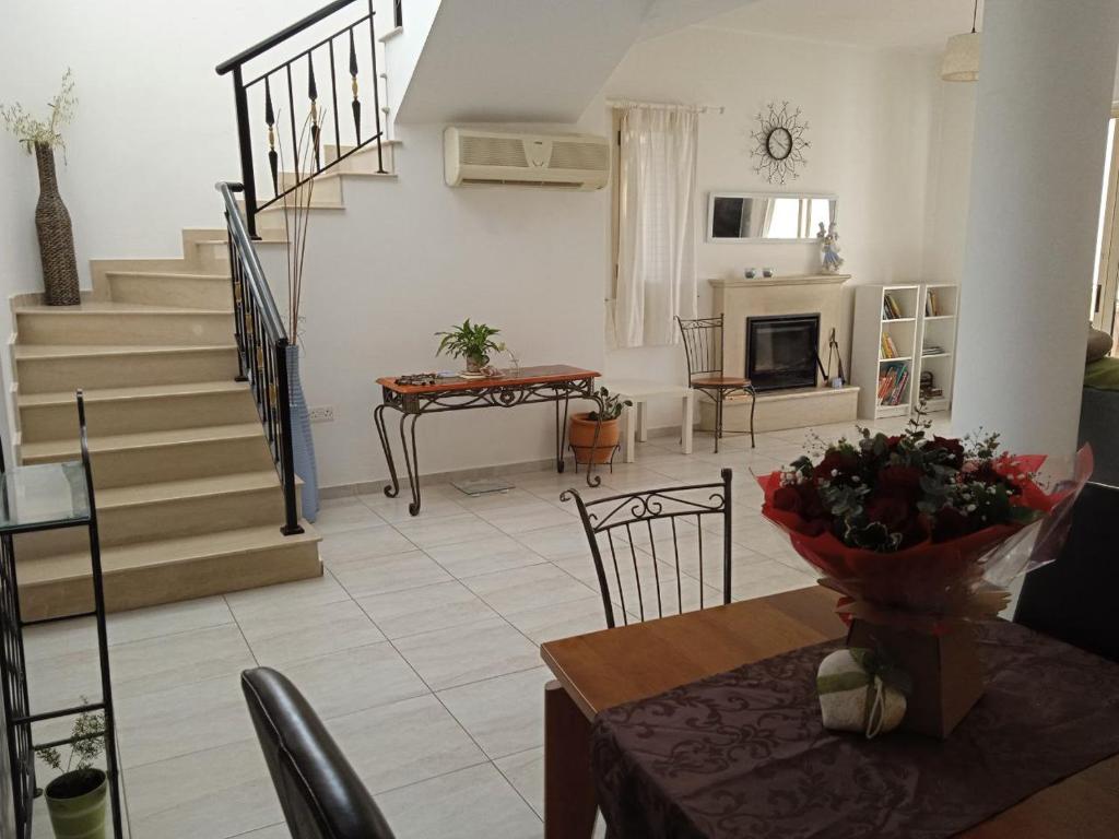 a living room with a staircase and a table and chairs at ZenBerry house in Mandria