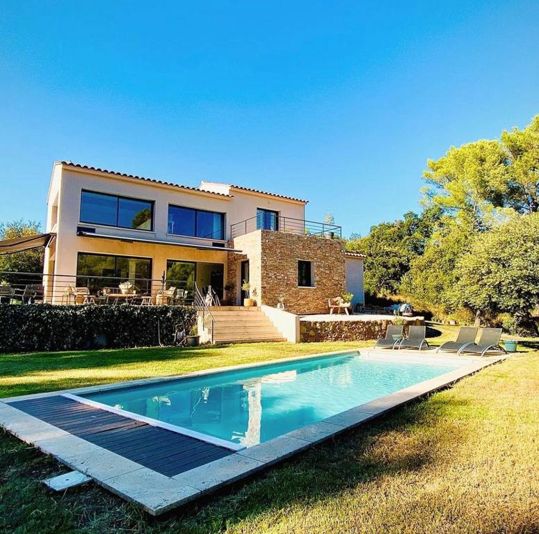 una casa con piscina frente a ella en La grange des amoureux piscine jacuzzi et massages, en Le Beausset