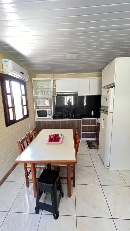 a kitchen with a table and a white refrigerator at La Casa de Gramado in Gramado
