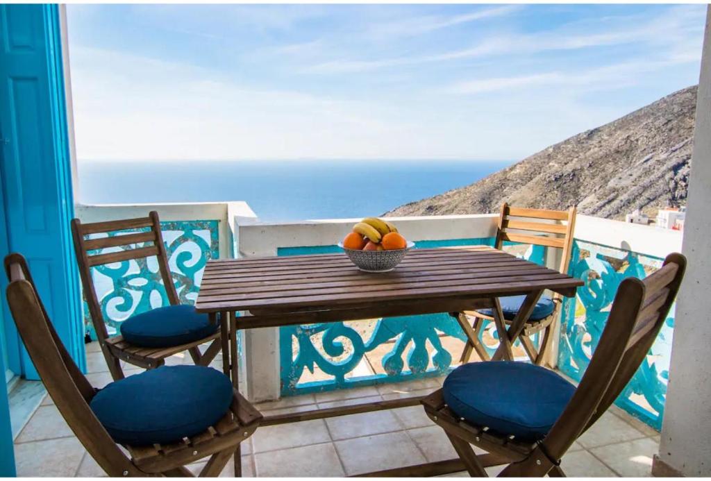 a table with chairs and a bowl of fruit on a balcony at Olympos Blue in Olympos