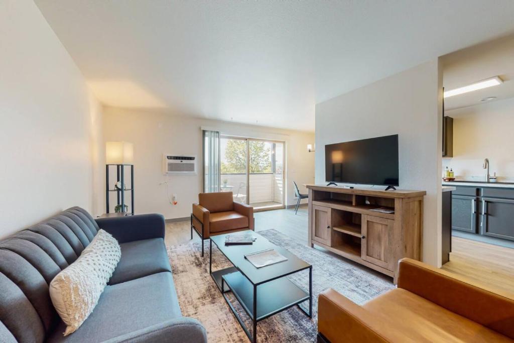 Una sala de estar con un sofá y un televisor de pantalla plana. en Modern Lofts at Aria 12, en Kalispell