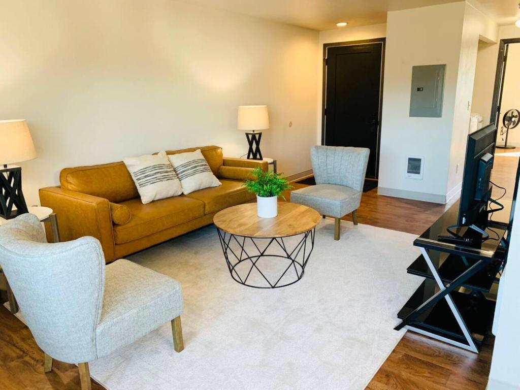 Una sala de estar con un sofá, una mesa y sillas. en Modern Lofts at Aria 11, en Kalispell