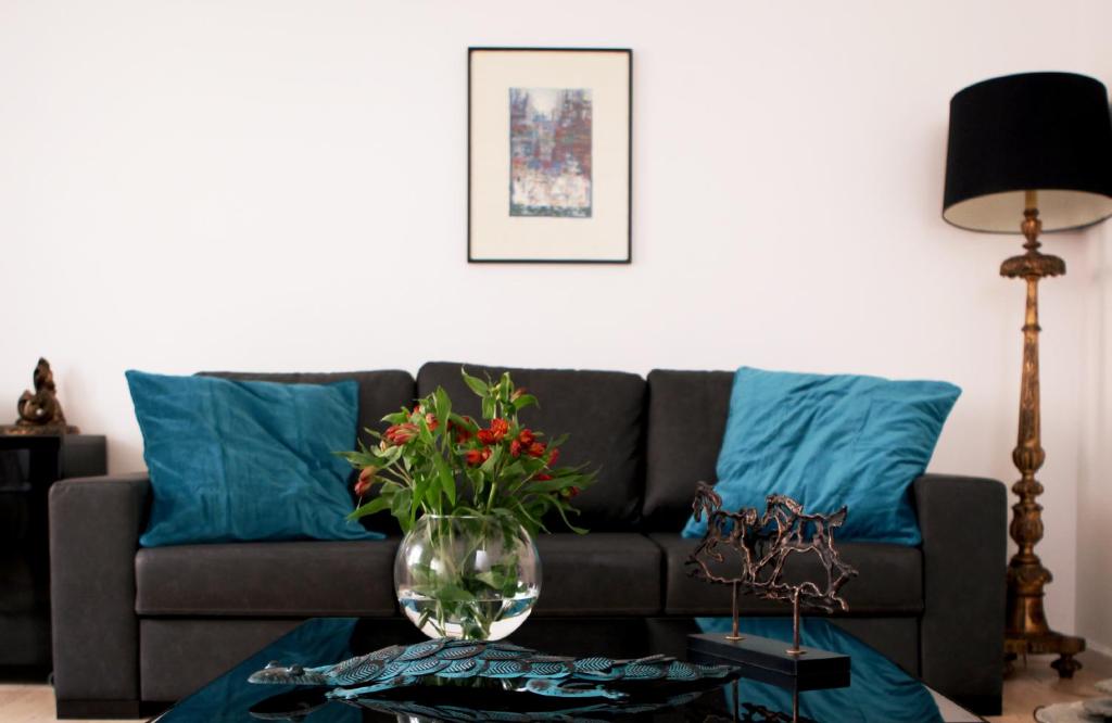 a living room with a couch with blue pillows at Triplex with Garage - Praça das Flores in Lisbon