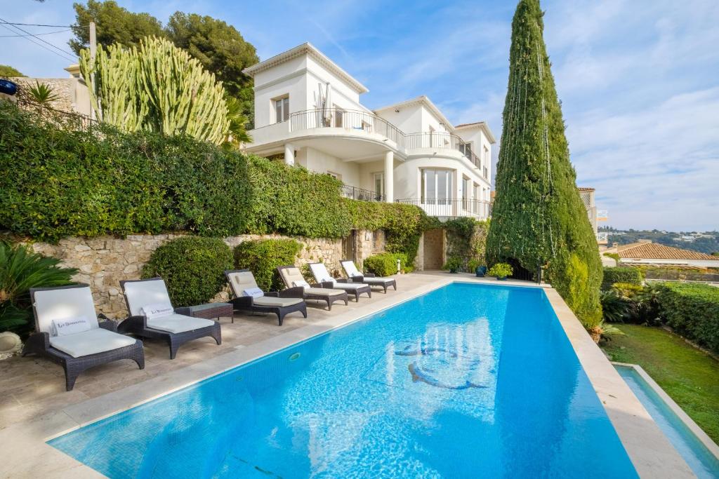 a villa with a swimming pool and a house at Villa Sorrentina in Villefranche-sur-Mer